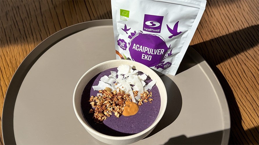 En acaibowl toppet med granola, n�ddesm�r og kokosflager p� en bakke sammen med Healthwell Acaipulver EKO.