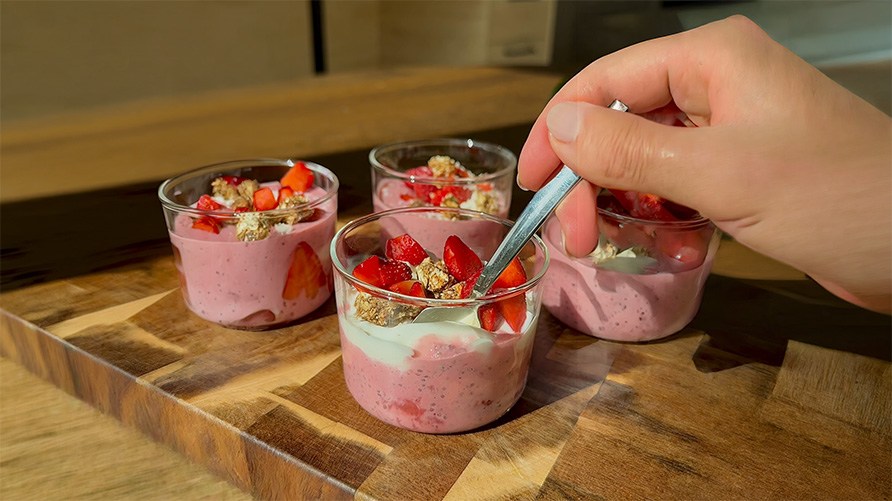 Fire glas med chiapudding med Healthwell Super Fruits p� en tr�bakke, der st�r p� en k�kkenbordplade.