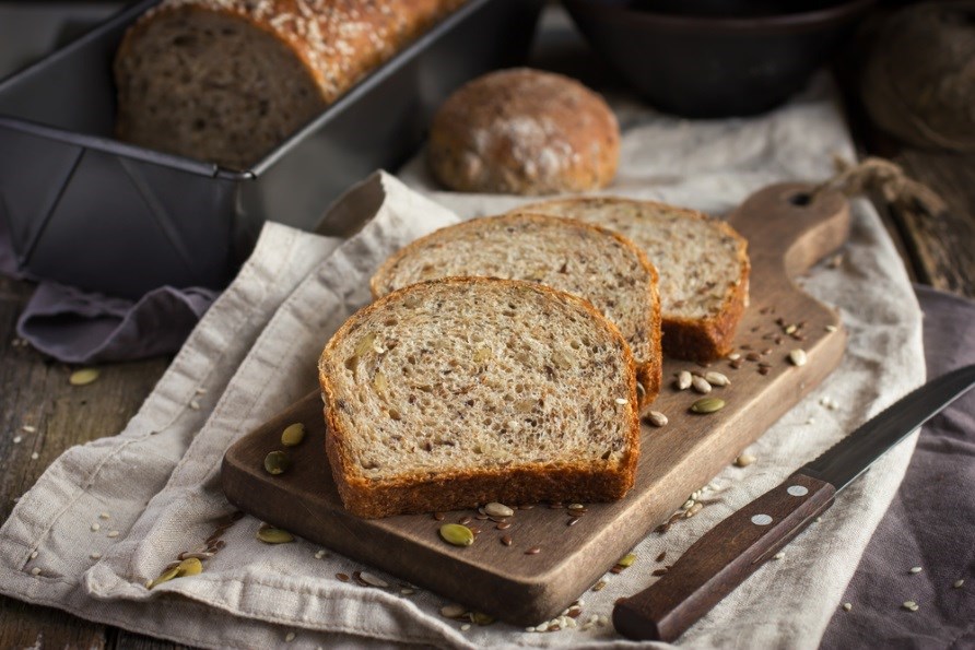 Et glutenfrit brd ligger skret i skiver p et skrebrt.