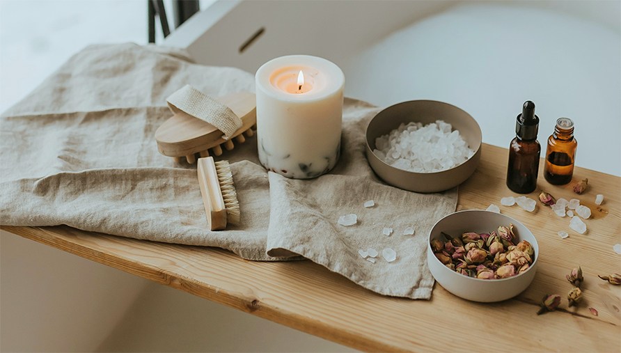 En bakke over et badekar med scrub, badesalt og æteriske olier. En bakke over et badekar med scrub, badesalt og æteriske olier.