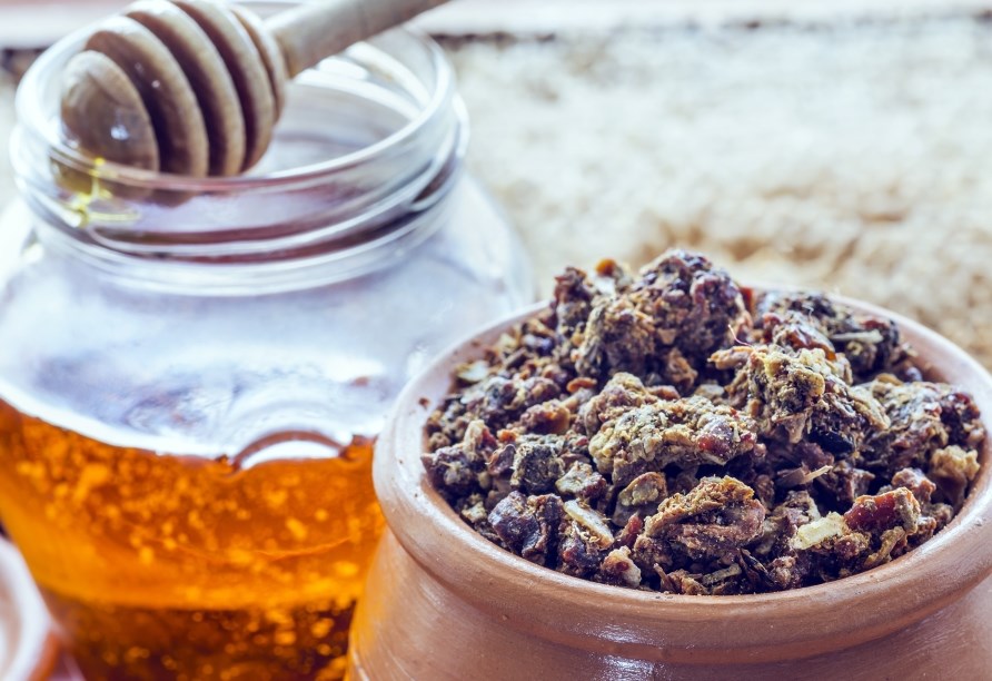 En krukke med propolis og et glas honing.