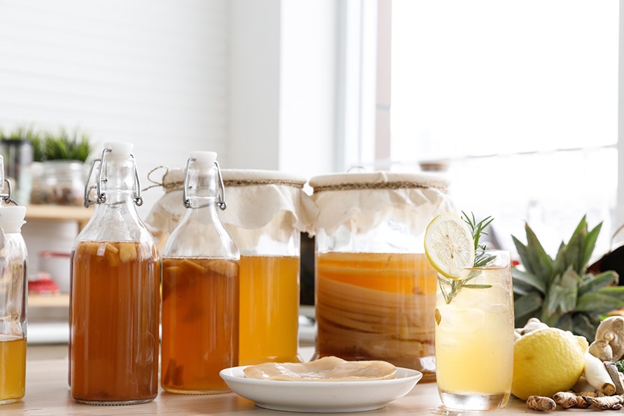 Glaskrukker og glasflasker, der er fyldt med kombucha.