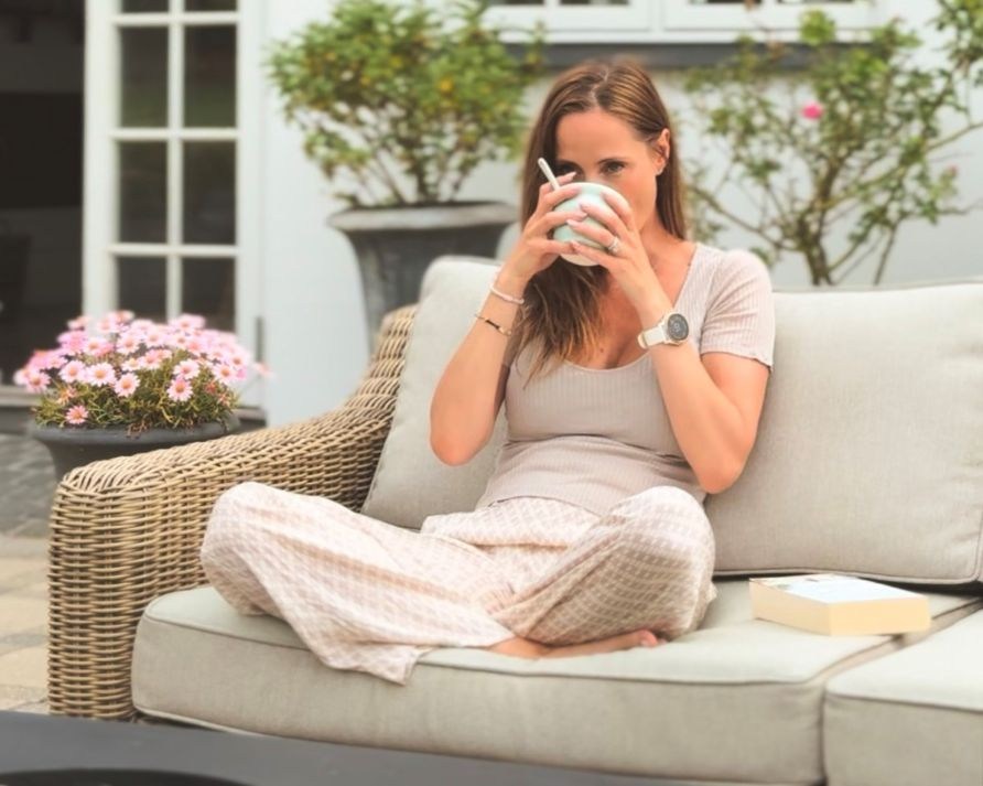 Lea Kessler sidder p en udendrssofa og drikker hendes matcha latte.