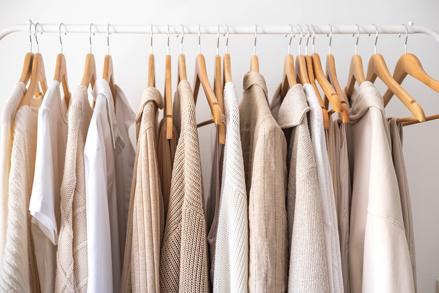 Tr�jer i forskellige hvide og beige nuancer h�nger p� b�jler.