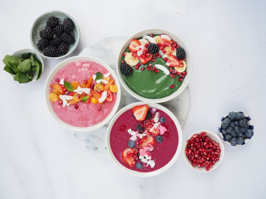Grn, hindbr-citron og acai-br smoothiebowl str p et bord sammen med nogle af ingredienserne