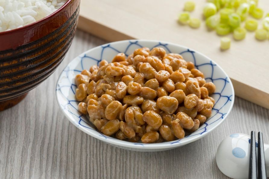 Natto - fermenterede sojab�nner serveret i en japansk sk�l med ris og hakket for�rsl�g ved siden af.