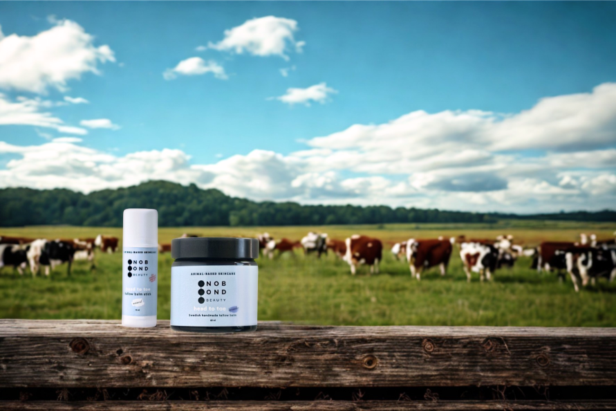 En eng med græssende køer, med to produkter fra No Bond Beauty på en træoverflade i forgrunden. En eng med græssende køer, med to produkter fra No Bond Beauty på en træoverflade i forgrunden.