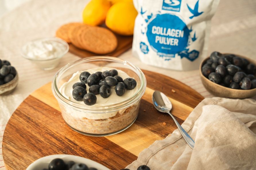 Overnight oats toppet med fl�deost og bl�b�r i en glassk�l.