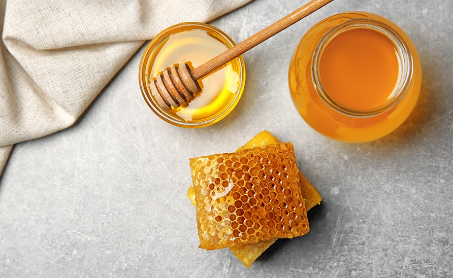 Honning i krukke med Bikager ved siden af.