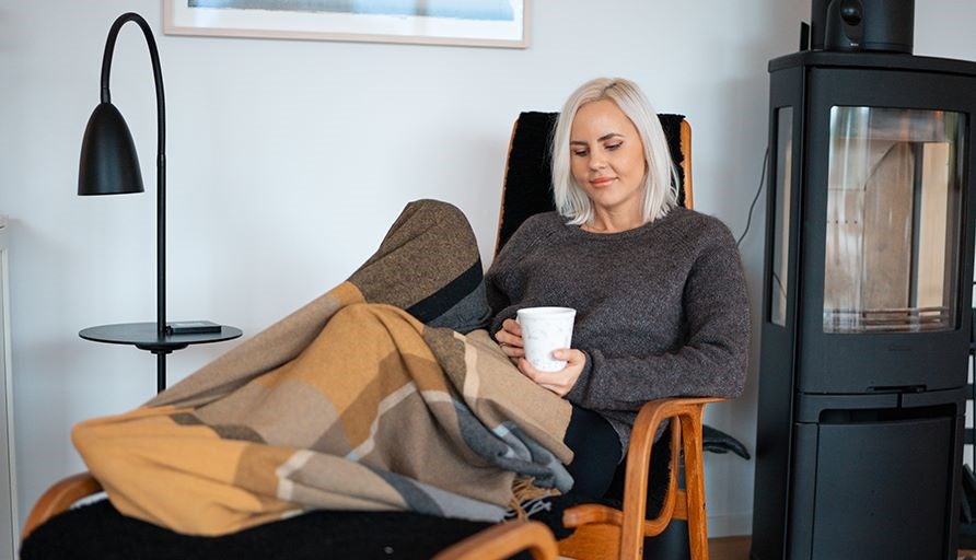 Susanna i en lnestol i en stue med en kop i hnden.